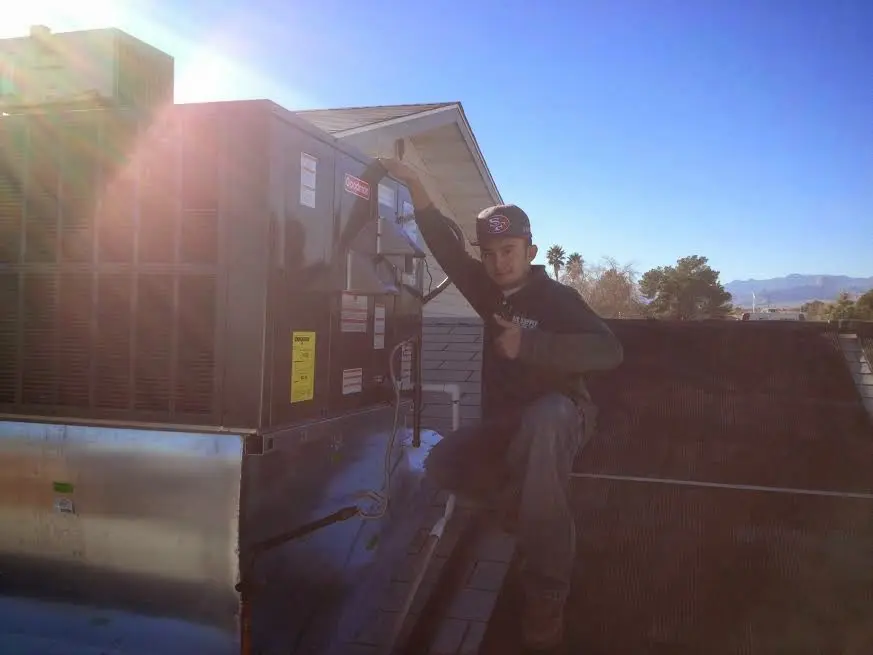 HVAC technician performing Boiler Repair on a rooftop unit in Newington
